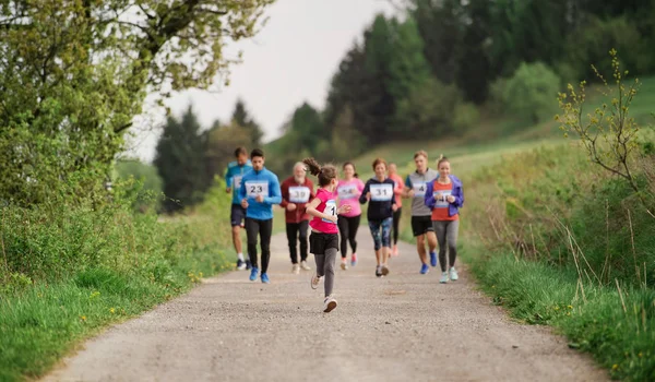 Több generáció nagy csoportja, akik versenyversenyt futtatnak a természetben. — Stock Fotó