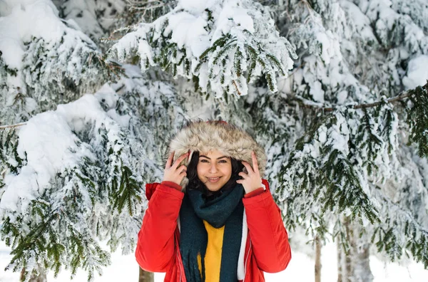 En front bild porträtt av ung kvinna stående utomhus i snöig vinter skog. — Stockfoto