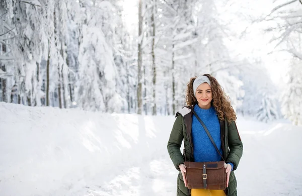 雪の冬の森の中で屋外に立っている若い女性の正面図. — ストック写真