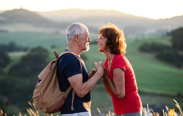 Senior turist par vandrare med ryggsäck stående i naturen, vila. — Stockfoto