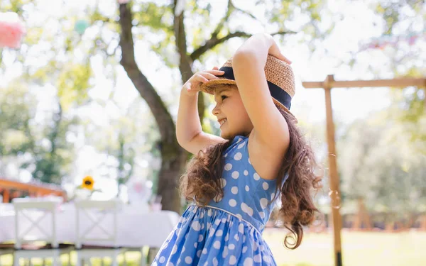 Piccola ragazza in piedi all'aperto in giardino in estate, concetto di festa di compleanno . — Foto Stock