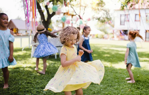 Kleine kinderen die in de zomer buiten in de tuin staan te spelen. — Stockfoto