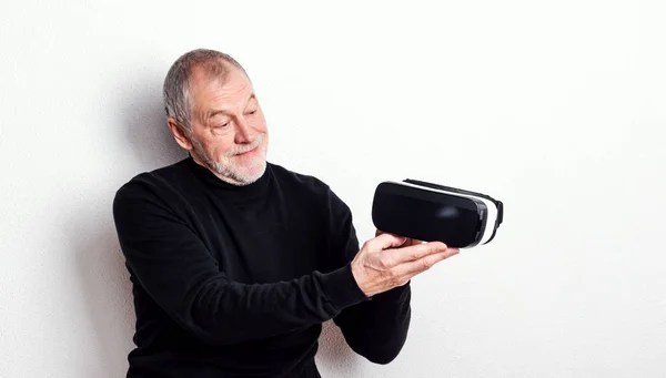 Porträtt av en glad senior man med Vr goggles i en studio. — Stockfoto