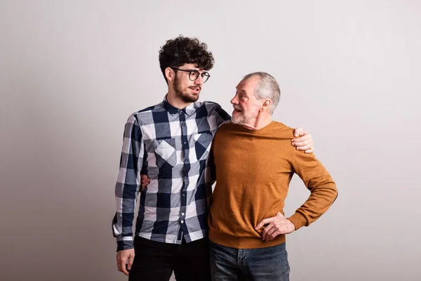 Retrato de un padre mayor alegre y un hijo pequeño en un estudio . —  Fotos de Stock