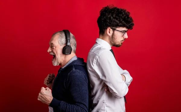 Studio shot di giovani contro vecchi generazioni, concetto di dipendenza tecnologica . — Foto Stock