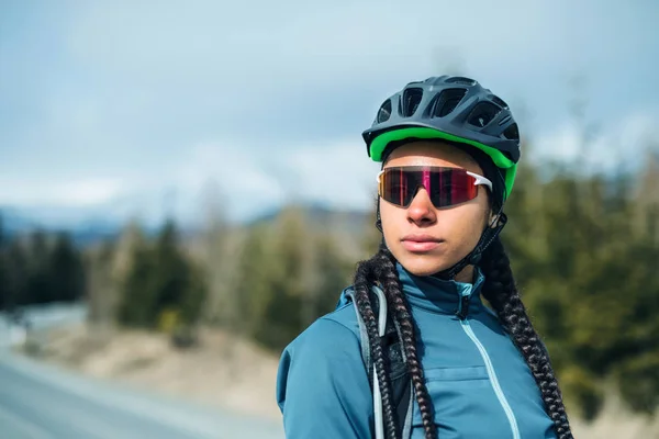 Mujer ciclista de montaña de pie en la carretera al aire libre en la naturaleza de invierno . — Foto de Stock