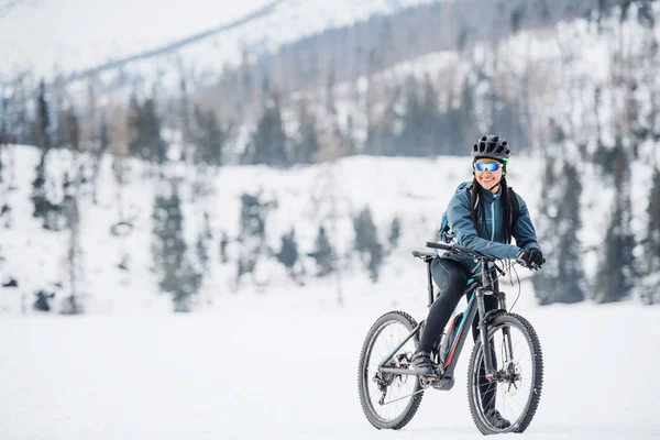 Γυναίκα ποδηλάτης βουνού με ποδήλατο στέκεται σε εξωτερικούς χώρους στη φύση το χειμώνα. — Φωτογραφία Αρχείου