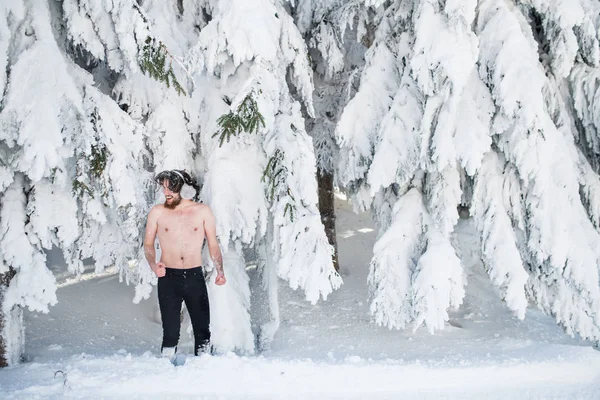 Kış ormanlarında kar altında üstsüz genç adam eğleniyor.. — Stok fotoğraf