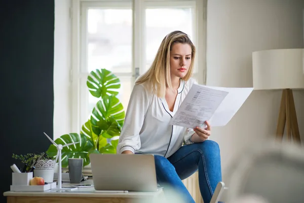 Junge Architektin sitzt im Homeoffice am Schreibtisch und arbeitet. — Stockfoto