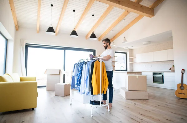 Felnőtt férfi dobozokkal és ruhaszárítóval költözik az új bútorozatlan házba. — Stock Fotó