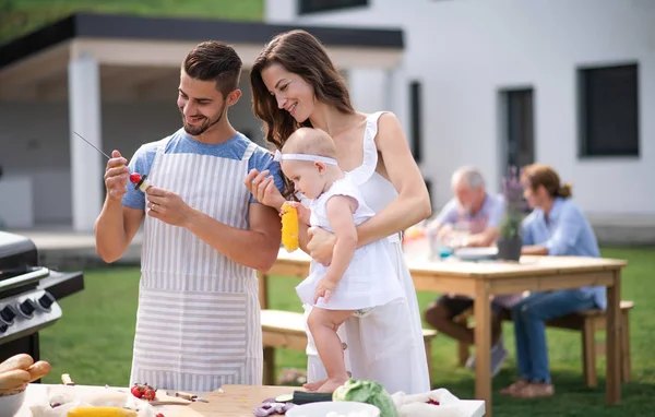 Retrato de familia con bebé al aire libre en el jardín barbacoa, parrilla . —  Fotos de Stock