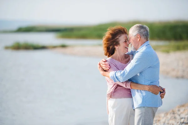 Pareja mayor de vacaciones en un paseo por el lago, abrazándose. Copiar espacio . — Foto de Stock