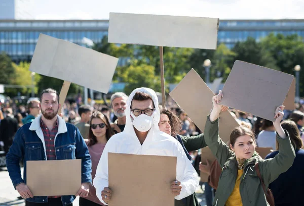 Personas con pancartas y traje de protección en huelga global por el cambio climático . — Foto de Stock