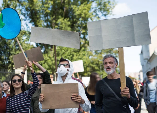 Personas con pancartas y traje de protección en huelga global por el cambio climático . —  Fotos de Stock