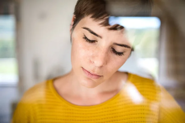 Vista frontal da jovem mulher triste em pé dentro de casa, close-up . — Fotografia de Stock