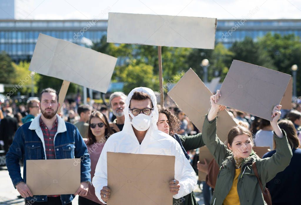 People with placards and protective suit on global strike for climate change.