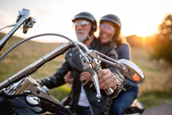 Wesoła para starszych podróżnych z motocyklem na wsi. — Zdjęcie stockowe