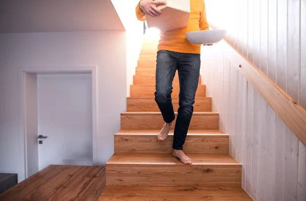 Homme méconnaissable avec des boîtes se déplaçant dans une nouvelle maison non meublée, marchant . — Photo