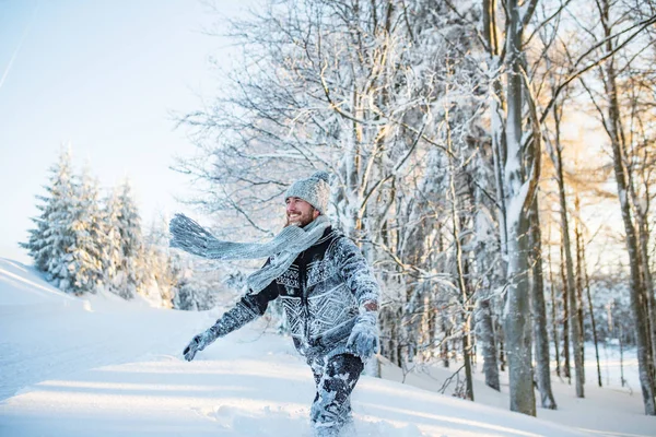 Jongeman heeft plezier in de sneeuw buiten in de winter. — Stockfoto