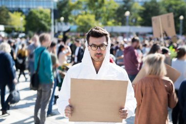 İklim değişikliği için küresel grev koruyucu takım elbise ve pankart ile adam portresi.