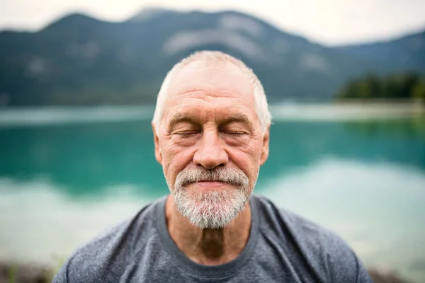 Un retrato de vista frontal del pensionista senior parado al aire libre en la naturaleza . — Foto de Stock