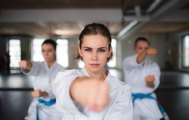 Spor salonunda karate yapan bir grup genç kadın..