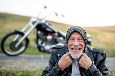Kırsalda motosikletle gezen neşeli, kıdemli bir gezgin..