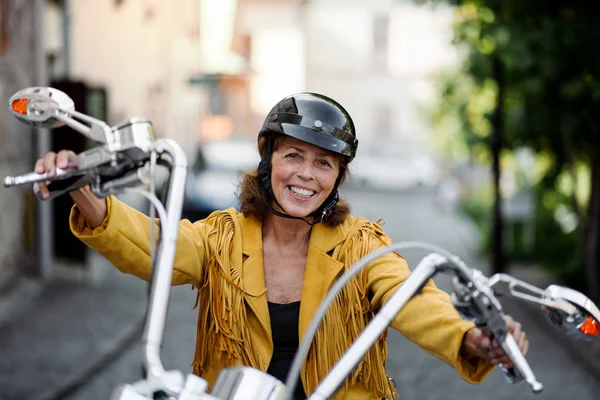 Mulher idosa alegre viajante com moto na cidade . — Fotografia de Stock