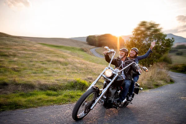 Fröhliches Seniorenpaar mit Motorrad auf dem Land unterwegs. — Stockfoto