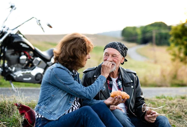 Una coppia di anziani allegri viaggiatori con moto in campagna . — Foto Stock