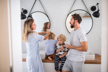 Banyoda iki küçük çocuğu olan genç bir aile. Konuşuyorlar..