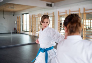 Spor salonunda karate yapan genç kadınlar..