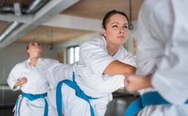 Spor salonunda karate yapan bir grup genç kadın..