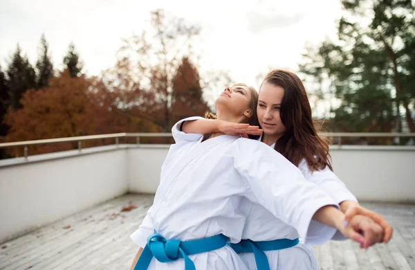 Jovens mulheres praticando karatê ao ar livre no terraço . — Fotografia de Stock