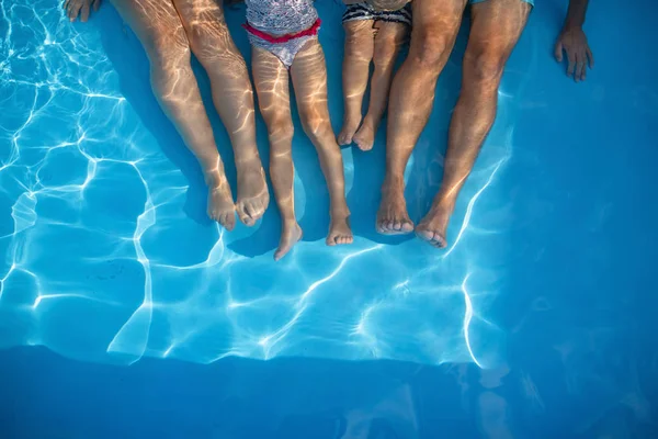 Μεσοτομή οικογένειας με μικρά παιδιά που κάθονται σε εξωτερική πισίνα. — Φωτογραφία Αρχείου