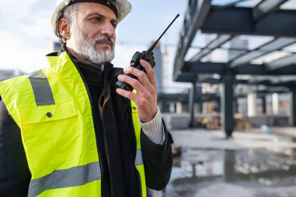 Man engineer using walkie talkie on construction site. — 스톡 사진