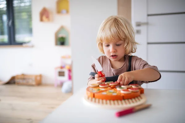 Lindo niño pequeño en el interior en el dormitorio jugando . — Foto de Stock