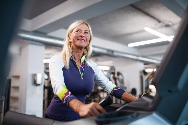 En äldre kvinna på gymmet tränar konditionsträning. — Stockfoto
