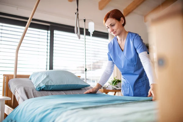 Retrato de enfermera o personal de limpieza cambiando sábanas en el hospital . —  Fotos de Stock