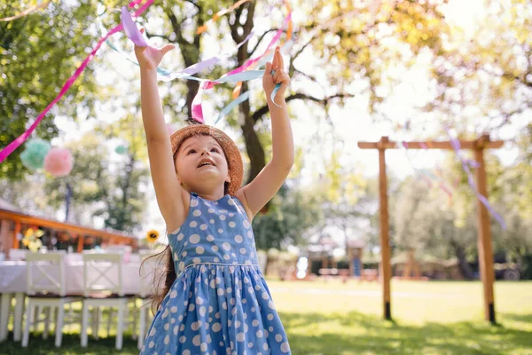 Klein meisje buiten in de tuin in de zomer, verjaardagsfeest concept. — Stockfoto
