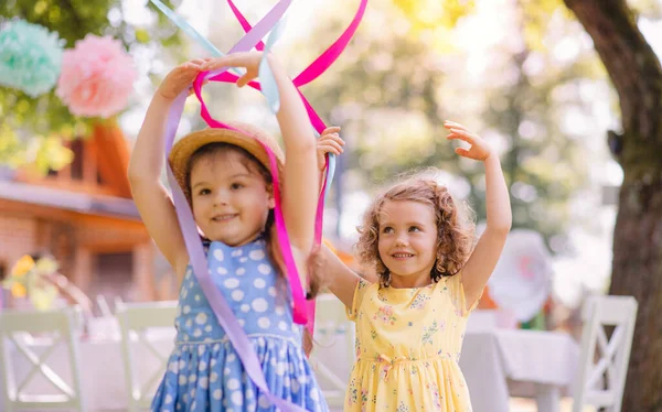 Piccole ragazze che giocano all'aperto in giardino in estate, concetto di festa di compleanno . — Foto Stock