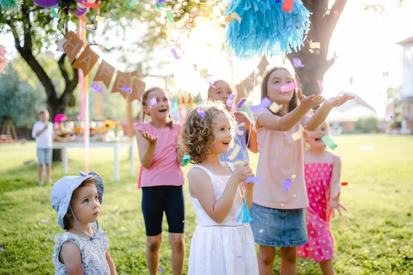 Kleine kinderen die in de zomer buiten in de tuin staan te spelen. — Stockfoto