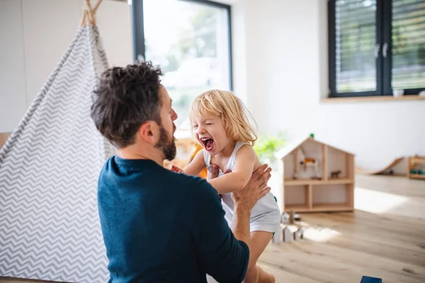 Junge Familie mit kleinem Kind drinnen im Schlafzimmer hat Spaß. — Stockfoto