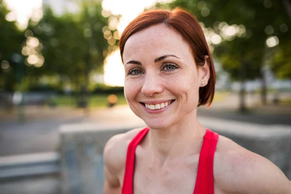 Frontansicht einer jungen Frau, die nach dem Sport im Freien in der Stadt steht und sich ausruht. — Stockfoto