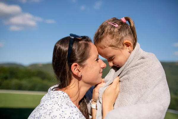 Madre secado hija con towwl al aire libre después de nadar . — Foto de Stock