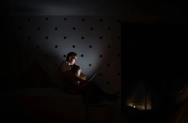 Πατέρας με παιδιά που κάθονται σε εσωτερικούς χώρους στην κρεβατοκάμαρα, χρησιμοποιώντας φορητό υπολογιστή. — Φωτογραφία Αρχείου