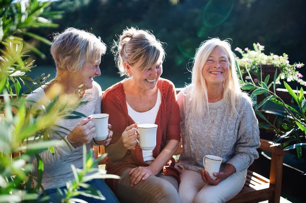 Mujeres amigas mayores con café sentado al aire libre en la terraza, descansando . — Foto de Stock