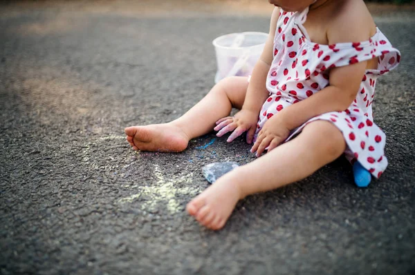 Unerkennbares Kleinkind auf dem Land, Kreidezeichnung auf der Straße. — Stockfoto