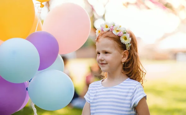 Klein meisje buiten in de tuin, verjaardagsfeest concept. — Stockfoto