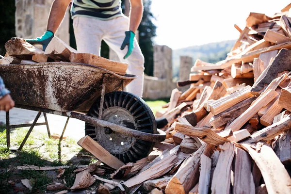 Unrecognizable man outdoors in summer, working with firewood. — Stock Photo, Image